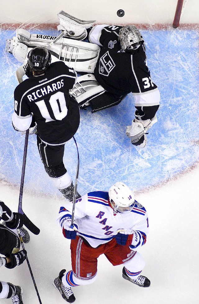 New York Rangers center Derick Brassard, bottom, celebrates after scoring past Los Angeles Kings goalie Jonathan Quick, top, and center Mike Richards during the second period of Game 2 in the NHL Stanley Cup Final hockey series in Los Angeles, Saturday, June 7, 2014. 