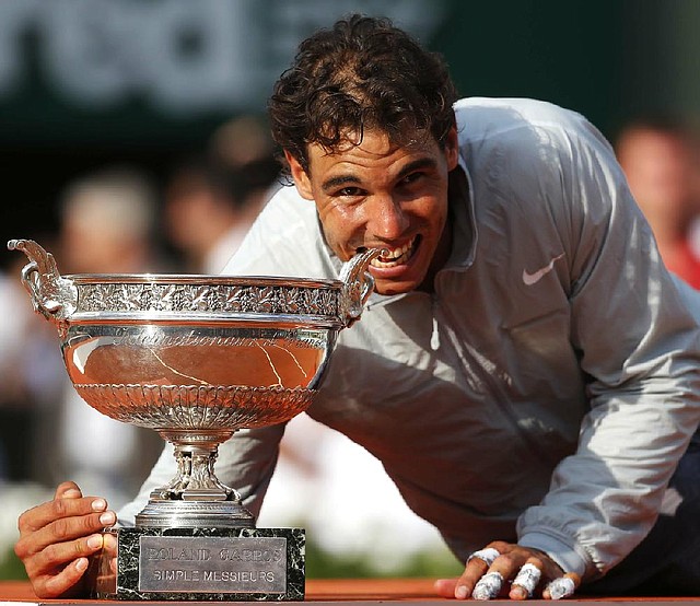 Rafael Nadal bites the French Open trophy after beating Novak Djokovic in four sets Sunday in the men’s final at Roland Garros Stadium in Paris.
