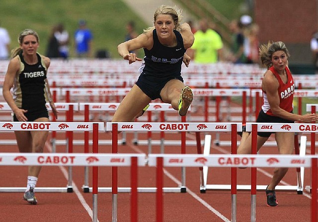 
Peyton Stumbaugh, center, from Springdale Har-Ber, set a new state overall record of 13.92 while competing in the Girls 110m Hurdles at the State 7A track championship Thursday in Cabot. Bentonville's Logan Morton, left, finished second, and Cabot's Tori Weeks, right, fell in the event.