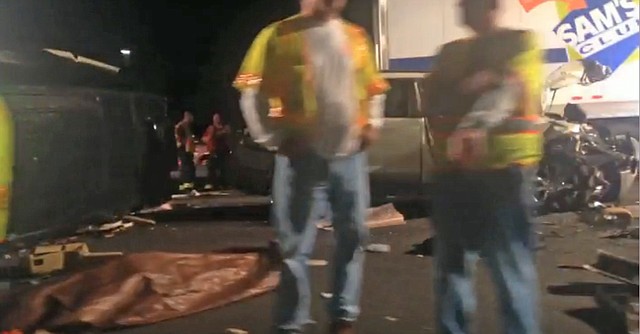 In this image from video the limousine bus carrying Tracy Morgan and six other people lies on it's side, left, as emergency responders work the accident scene early Saturday morning June 7, 2014 on the New Jersey Turnpike. Morgan remained hospitalized as state and federal officials continued their investigation of the six-vehicle crash on the New Jersey Turnpike that took the life of a Morgan friend and left two others seriously injured, authorities say. 