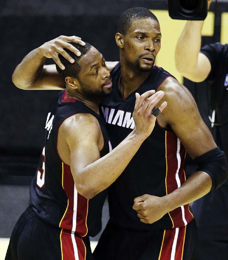 Miami Heat guard Dwyane Wade  (3) and teammate Chris Bosh celebrate after beating the San Antonio Spurs 98-96 on Sunday.