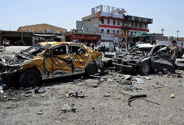 Civilians and security officers inspect the site of a suicide bomb attack in Tuz Khormato, 130 miles north of Baghdad, Iraq, on Monday.