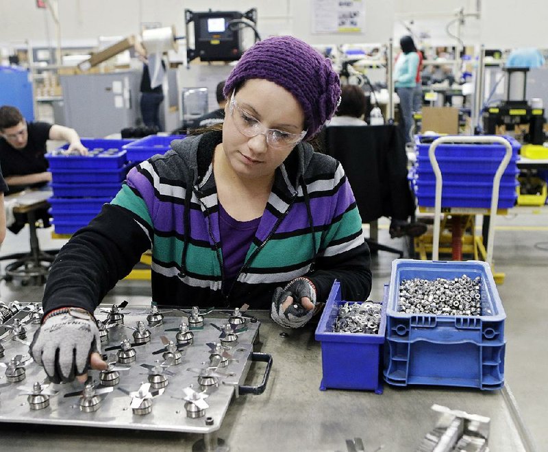 An employee at the Vitamix factory in Strongsville, Ohio, assembles blender blades in this April photo. A survey of business economists released Monday said the U.S. economy will expand at a 3.5 percent annual rate in the second quarter.