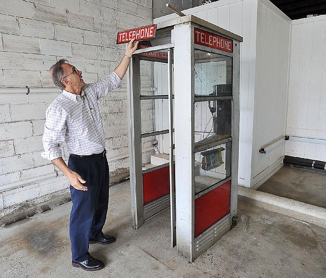 David Parks, president of the Prairie Grove Telephone Co., shows the damage to the telephone booth that was located in front of the Colonial Motel on U.S. 62 in Prairie Grove for four decades.The booth was hit Saturday by a Chevy Tahoe.