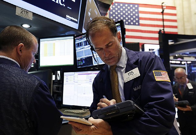 Trader Mark Puetzer works Monday on the •oor of the New York Stock Exchange. The Standard & Poor’s 500 index closed at another all time high.