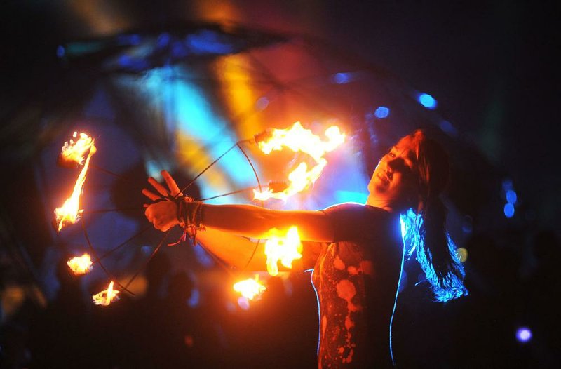 A member of the VibeTribe from Kansas City performs a fire dance in front of the main stage as the String Cheese Incident performs late Saturday evening at the 2014 Wakarusa music festival on Mulberry Mountain in Ozark Arkansas. The 4 day festival featured music, art Installations and performance troupes for over 20,000 festival attendees. 