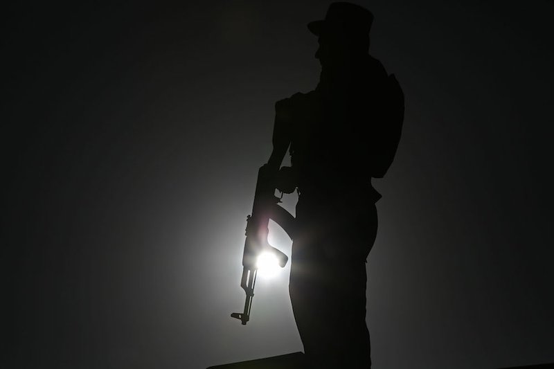 An Afghan police officer stands guard during a campaign rally in the Paghman district of Kabul, Afghanistan, Monday, June 9, 2014. The second round of Afghanistan's presidential election will take place on June 14, 2014. 