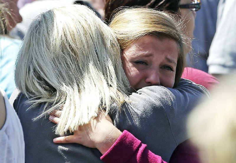 Freshman Hailee Siebert, 15, is hugged by her mother after students arrived at a shopping-center parking lot Tuesday in Wood Village, Ore., after a shooting at Reynolds High School in nearby Troutdale. A gunman killed a student at the high school, east of Portland. The gunman is also dead,