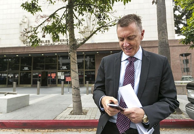 Los Angeles Unified School District Superintendent John Deasy checks his phone Tuesday outside the Stanley Mosk Courthouse while awaiting the verdict in the Vergara v. California lawsuit in Los Angeles. A judge struck down tenure and other job protections for California’s public-school teachers as unconstitutional.