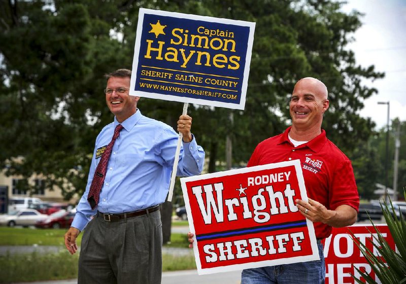 Simon Haynes (left) and Rodney Wright — both Saline County Republican candidates for sheriff — campaign side-by-side Tuesday morning outside the voting site at Grace Church in Bryant.