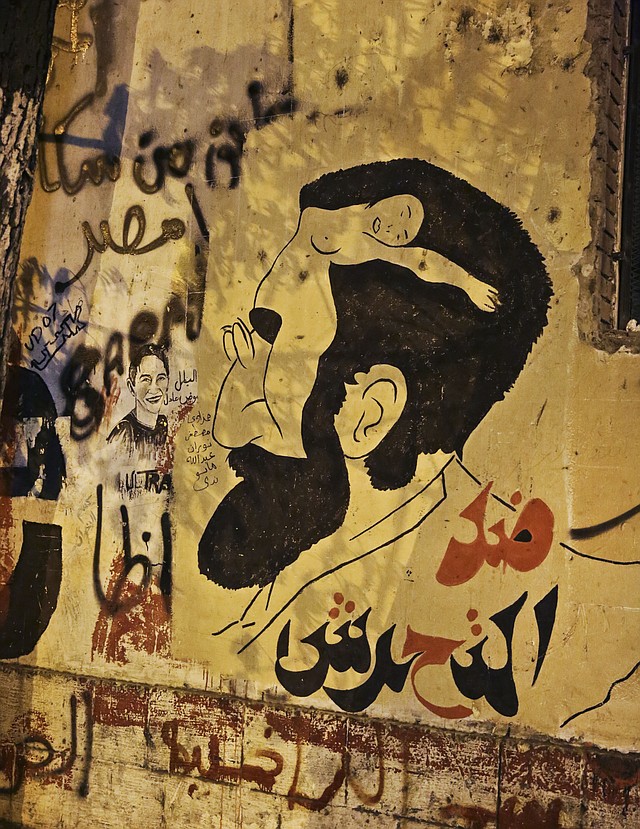 In this Sunday, June 8, 2014 photo, anti-sexual harassment graffiti has been painted on a wall near Tahrir Square, Cairo, Egypt. Egyptian police on Monday arrested seven men for sexually assaulting a 19-year-old student during celebrations marking the inauguration of the country's new president in Cairo's central Tahrir Square the day before, security officials said. Sexual harassment has been one of Egypt enduring social ills, prompting authorities last week to issue a decree declaring it a crime punishable by up to five years in prison. Arabic reads, "against harassment."