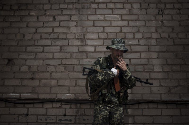 A pro-Russian fighter from a group that calls itself "Russian Orthodox Army"  poses for photo in Donetsk, eastern Ukraine, Tuesday, June 10, 2014. Ukraine's new president on Tuesday ordered security officials to create a corridor for safe passage for civilians in eastern regions rocked by a pro-Russian insurgency, as he began to form his government team by tapping a media mogul as chief of staff. 