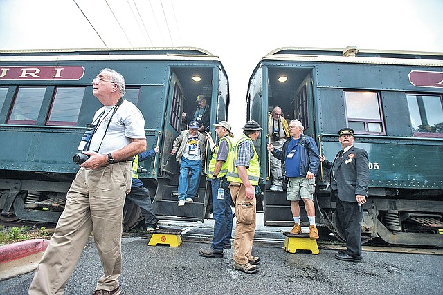 STAFF PHOTO ANTHONY REYES Train enthusiasts leave from a pair of Arkansas &amp; Missouri Railroad passenger cars Tuesday to take pictures at a crossing in Bentonville.