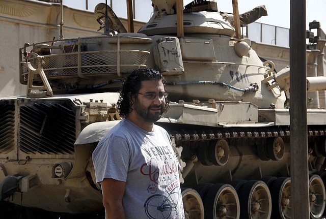 Prominent Egyptian blogger Alaa Abdel-Fattah stands in front of a criminal court in Cairo, Egypt, Wednesday, June 11, 2014. A court has convicted Abdel-Fattah for demonstrating without permit and assaulting a policeman, sentencing him to 15 years in prison.