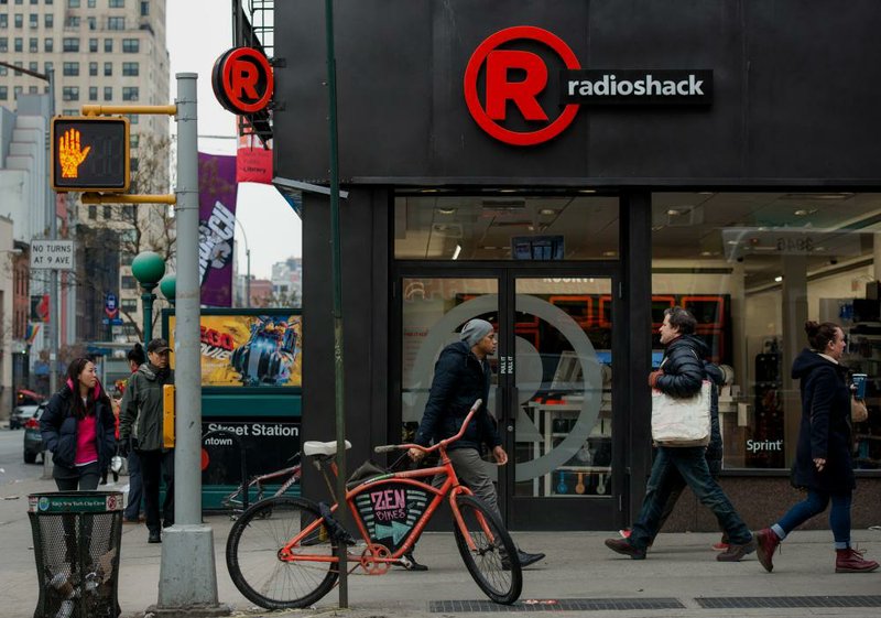 Pedestrians pass a RadioShack Corp. store in New York in March. The chain of electronics stores is struggling to revive its business during an industrywide slump in electronics demand.