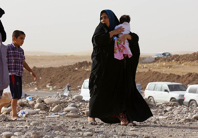 An Iraqi woman and child arrive Wednesday at a refugee camp outside Irbil, about 200 miles north of Baghdad, after fleeing the fighting in Mosul. Officials said about 500,000 people had left the city.