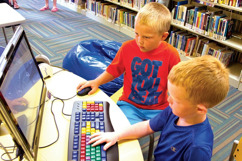 Colby Boyd, left, and Corey Boyd play on a computer at the newly renovated Mary I. Wold Cleburne County Library in Heber Springs. The facility’s renovations include defined areas for children and genealogy, as well as computers and outlets to accommodate patrons. The library opened June 4 and has already seen checkouts triple.