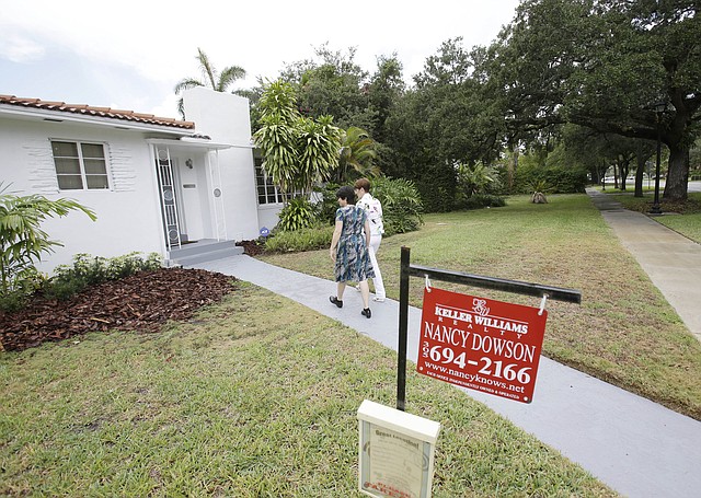 In this Thursday, May 29, 2014 photo, real estate broker Nancy Dowson, center right, with Keller Williams Realty, shows a house to prospective buyer Mary Tuttle, center, in Miami Shores, Fla. Freddie Mac releases weekly mortgage rates on Thursday, June 12, 2014.