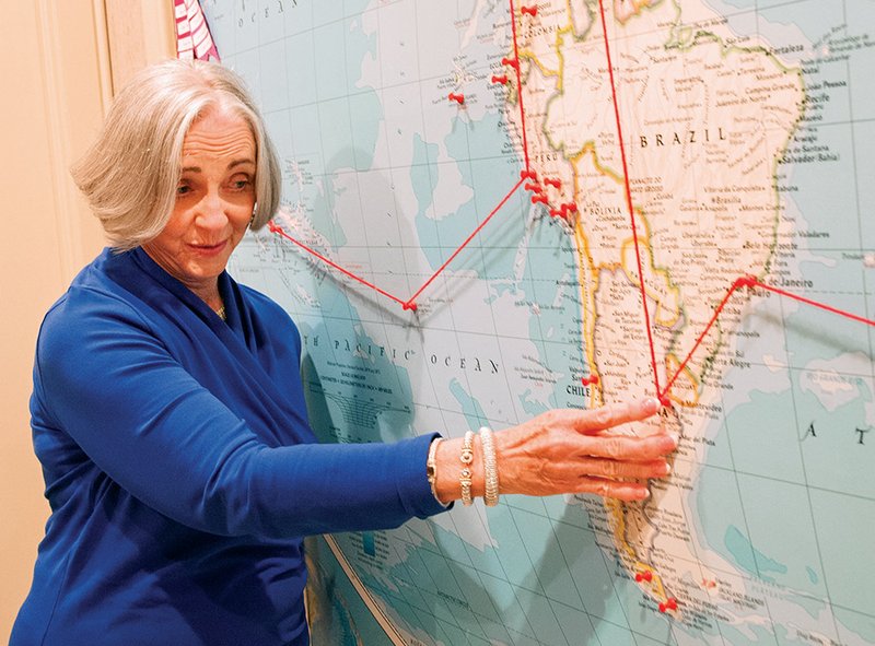 Joyce Faulkner points out locations on a large map in the couple’s travel room that shows all the places they visited over the years.