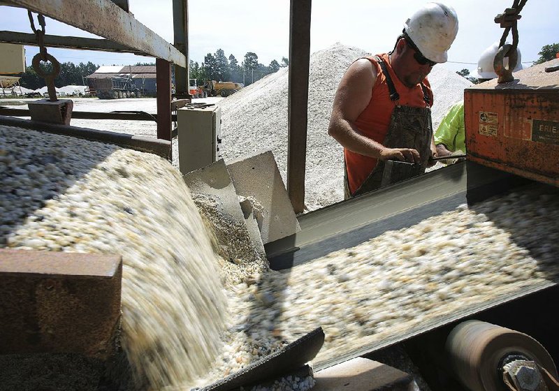  Arkansas Democrat-Gazette/STATON BREIDENTHAL --6/12/14-- Employee Brian Lain of Arkansas Decorative Stone monitors a crushing machine Thursday as raw material pours onto a conveyor belt at the Grant County company. 