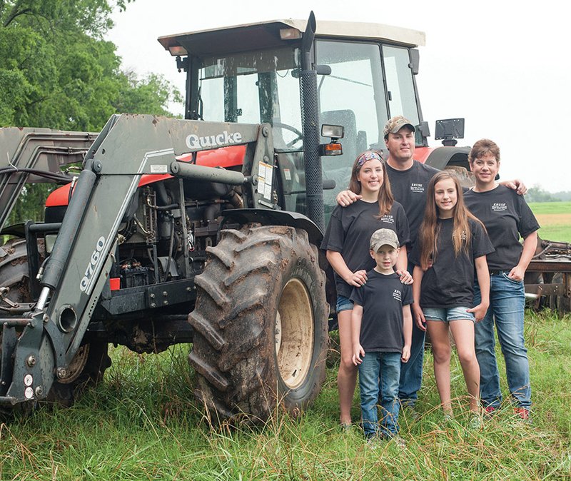 From left, Bethany, Samuel, Joey, Baylee and Beth Hutchison stand by their tractor in a hayfield on the family’s farm.