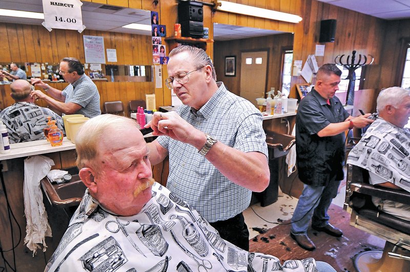 STAFF PHOTO BEN GOFF &#8226; @NWABenGoff Charlie Turner gives Arthur Henderson a haircut Thursday at Charlie&#8217;s Barber Shop on South Main Street in Bentonville. Henderson is one of a handful of loyal customers who have been getting haircuts from Turner since he opened shop in Bentonville 50 years ago.
