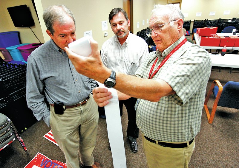 STAFF PHOTO JASON IVESTER Mike McKenzie, from left, and Ron Easley watch Friday as John Brown Jr., Benton County Election Commission chairman, explains the printout from electronic ballots at the Election Commission office in Bentonville. McKenzie, the incumbent, called for a recount in the Quorum Court District 1 race, which he lost by five votes to Easley. After the recount, the total was confirmed.