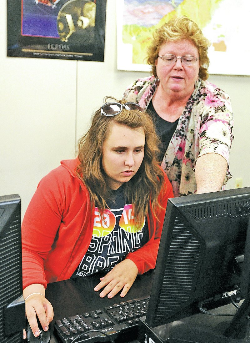 STAFF PHOTO BEN GOFF &#8226; @NWABenGoff Professor Dianne Phillips, right, helps Lindsay Pardun with an exercise studying earthquakes during a physical science class.