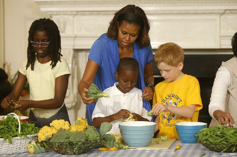 First lady Michelle Obama helps students make a salad Thursday with greens and vegetables harvested from the White House garden as part of her campaign for better nutrition for children.