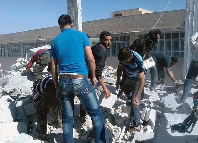 Syrians inspect the rubble of houses that were destroyed by airstrikes from the Syrian government Sunday in Idlib province, northern Syria.