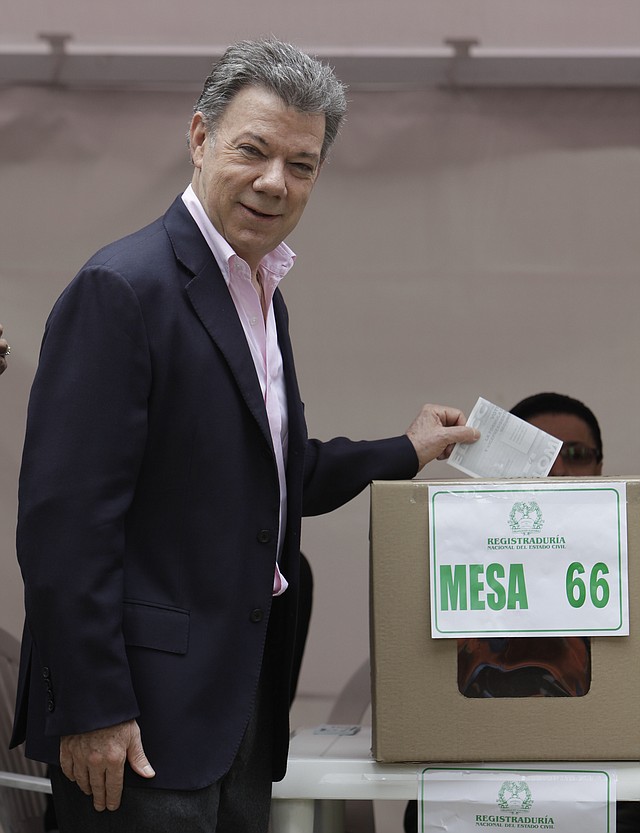 President Juan Manuel Santos casts his ballot during presidential elections in Bogota, Colombia, Sunday, June 15, 2014. Santos is seeking a second four-year term as candidate for the Social Party of National Unity. 