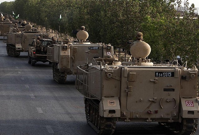 Pakistani army troops in armored personnel carriers parade through Karachi on Monday.