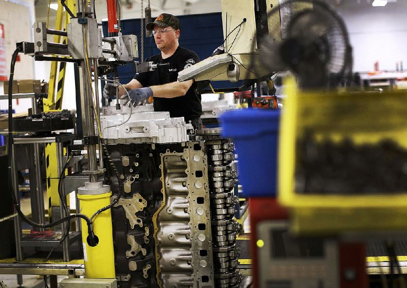 An assembly line worker installs parts on a truck engine March at Volvo Trucks’ powertrain manufacturing facility in Hagerstown, Md. Factory output rose 0.6 percent in May, the Federal Reserve said Monday.