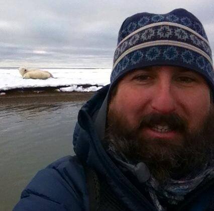 Jason Matthews with a polar bear in Arctic National Wildlife Refuge where he spent last fall looking for polar grizzly hybrids. 
