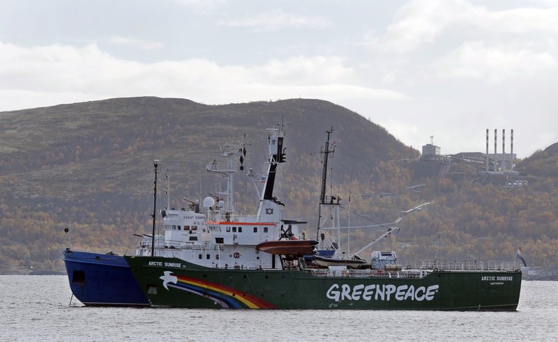  In this Tuesday, Sept. 24, 2013 file photo, Greenpeace ship 'Arctic Sunrise'  is escorted by a Russian coast guard boat, in Kola Bay at the military base Severomorsk on the Kola peninsula in Russia, at dawn. Greenpeace has suffered a 3.8 million-euro ($5.2 million) loss on an ill-timed bet in the currency market by a well-intentioned  if reckless  employee in its financial unit. The environmental group, which is based in Amsterdam, said Monday, June 16, 2014,  the employee  who had bet the euro would not strengthen against other currencies in 2013, when it did  had acted beyond the limits of his authority.