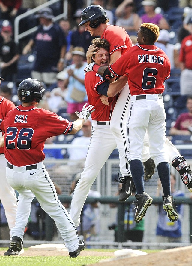 Ole Miss’ Aaron Greenwood (second from right) celebrates scoring the winning run against Texas Tech on Tuesday with Brantley Bell (28), John Gatlin (second from left) and Errol Robinson (6).