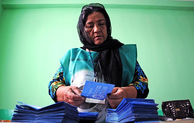 An Independent Election Commission employee counts ballots Saturday at a polling station in Mazar-i-Sharif, Afghanistan. Observers said Saturday’s presidential runoff ran smoothly, although numerous allegations of fraud have been filed.