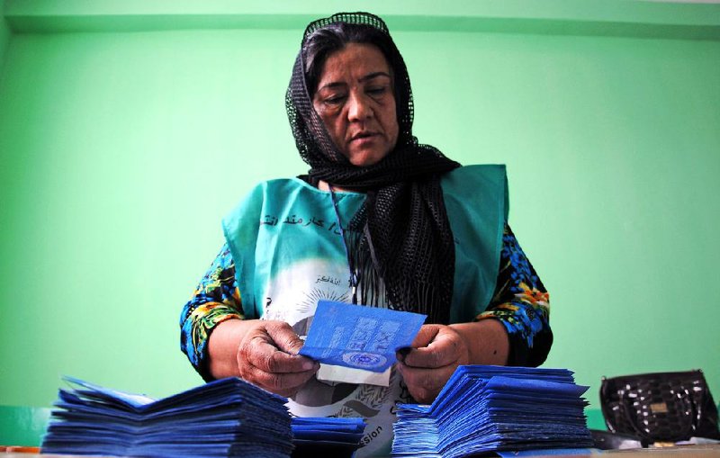 An Independent Election Commission employee counts ballots Saturday at a polling station in Mazar-i-Sharif, Afghanistan. Observers said Saturday’s presidential runoff ran smoothly, although numerous allegations of fraud have been filed.