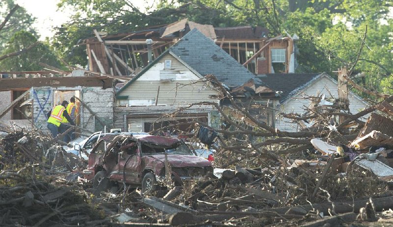 Officials walk through the tornado damaged town of Pilger, Neb.,  on Tuesday,  June 17, 2014. The National Weather Service says the storm that struck northeast Nebraska appears to have produced four tornadoes, one of which ravaged the town of Pilger.   (AP Photo/The World-Herald, Ryan Soderlin) MAGS OUT; ALL NEBRASKA LOCAL BROADCAST TV OUT