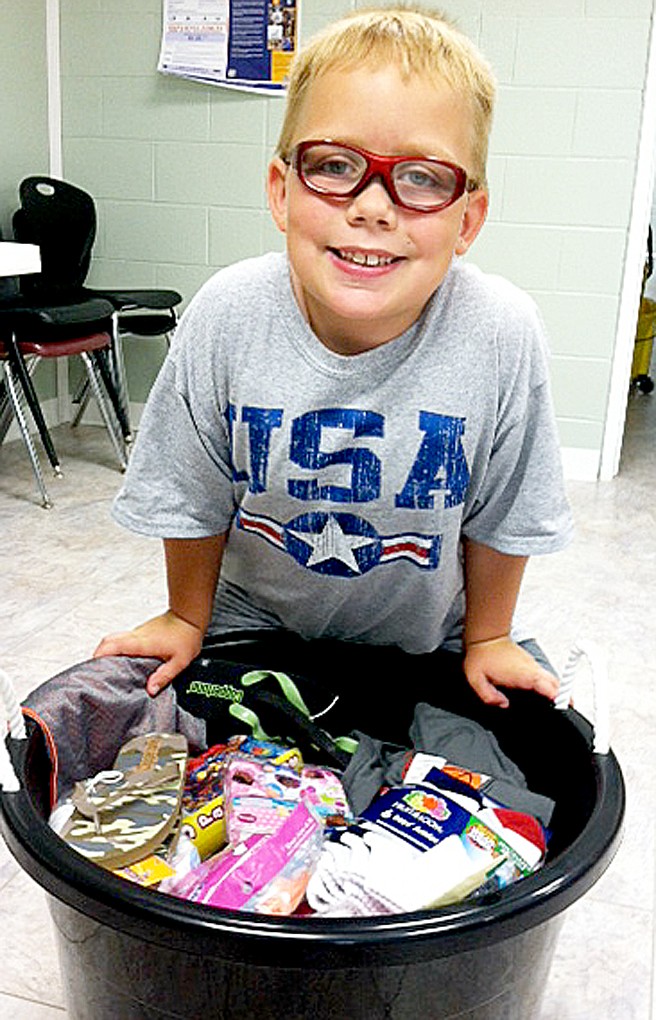 TIMES photograph by Annette Beard For his birthday, Jace Dye asked for donations for others instead of gifts for himself. The 7-year-old son of John and B.J. Dye, Jace said: &#8220;Well, I saw people and that they were doing that &#8212; giving &#8212; and so I thought I could do it to make people happy. I asked my friends to bring clothes for donations. I wanted to make other families happy.&#8221; Jace&#8217;s birthday was May 31. He said his father goes to Haiti &#8220;where people are really poor.&#8221; Jace gave a bucket of new clothing items to Bright Futures, Pea Ridge, which gives to children in the Pea Ridge School district.