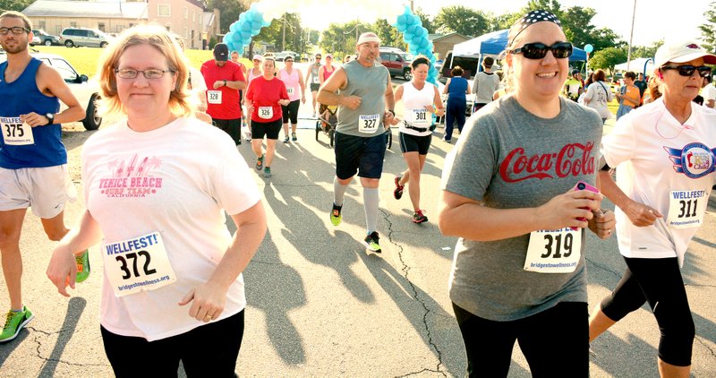 Jeff Della Rosa/Herald-Leader Angie Ostberg of Siloam Springs runs with Elizabeth Smith in the 5K. Smith trained Ostberg for the 5K after Smith received training for a half marathon.