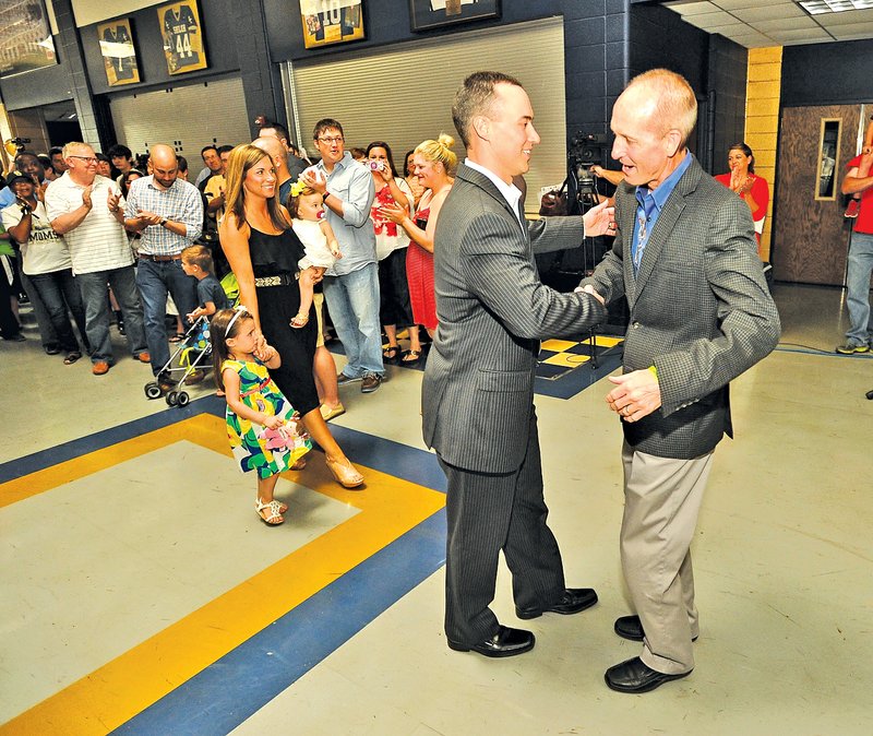  Staff Photo Michael Woods w @NWAMICHAELW Jeff Conaway, left, new Shiloh Christian football coach, shakes hands with Ben Mayes, Shiloh Christian president, as Conaway and his family are introduced during a news conference Tuesday at Shiloh Christian in Springdale.