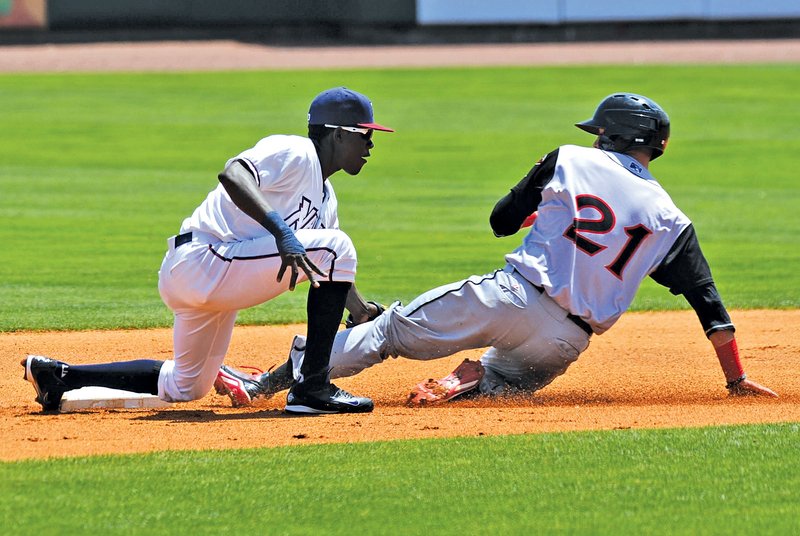  STAFF PHOTO ANDY SHUPE Orlando Calixte, left, Northwest Arkansas Naturals shortstop, applies the tag Wednesday as Arkansas Travelers third baseman Kaleb Cowart attempts to steal second base during the first inning at Arvest Ballpark in Springdale.