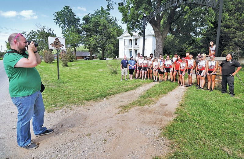 STAFF PHOTO BEN GOFF &#8226; @NWABenGoff Todd Crow, left, public relations writer for the Cherokee Nation, takes a photo of the 20 cyclists and support team with the Remember the Removal bike ride in front of Fitzgerald&#8217;s Station on Old Wire Road in Springdale.