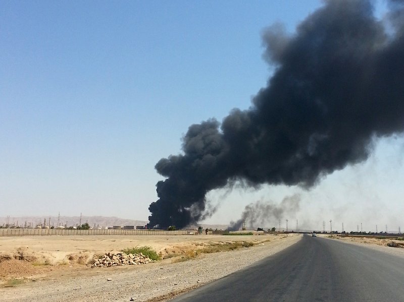 A column of smoke rises from an oil refinery in Beiji, some 250 kilometers (155 miles) north of Baghdad, Iraq, Thursday, June 19, 2014. The fighting at Beiji comes as Iraq has asked the U.S. for airstrikes targeting the militants from the Islamic State of Iraq and the Levant. 
