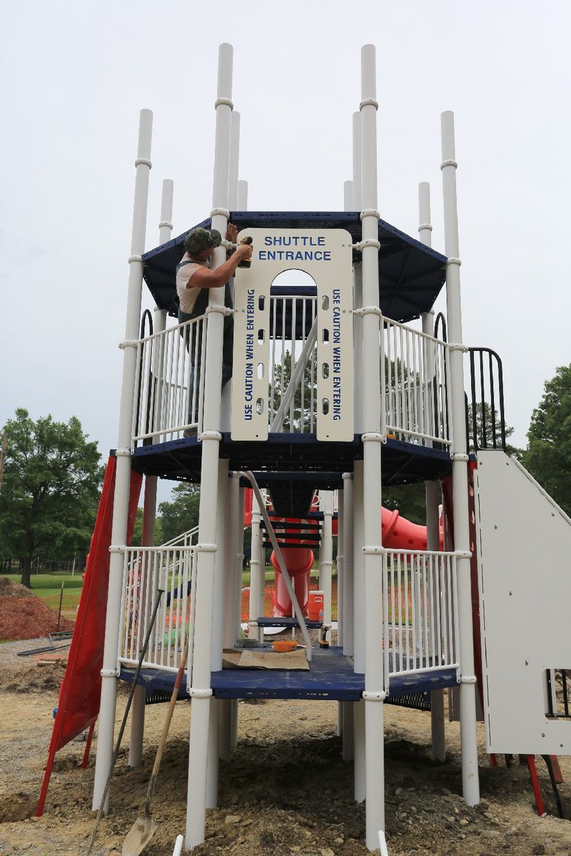 Skip Martin, with Ozark Mountain Installations in Missouri, works on the new Rocket Slide being built in Burns Park in North Little Rock on Thursday, June 5, 2014. The one being replaced was vandalized and set on fire Jan. 25.