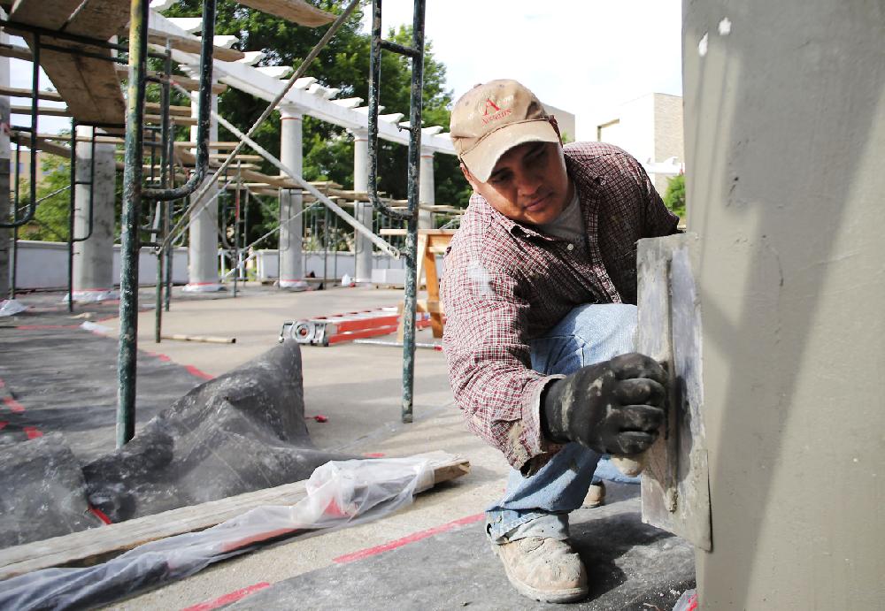 NWA Media/DAVID GOTTSCHALK - 6/19/14 - Adolfo Ramos, with Martin‚Äôs Painting and Stucco Company of Springdale, applies stucco to the columns of the University of Arkansas Chi Omega Greek Theatre on the campus in Fayetteville Thursday June 19, 2014. Renovation work continues on the theatre that was was completed in the summer of 1930 and listed on the National Register of Historic Places in 1992.