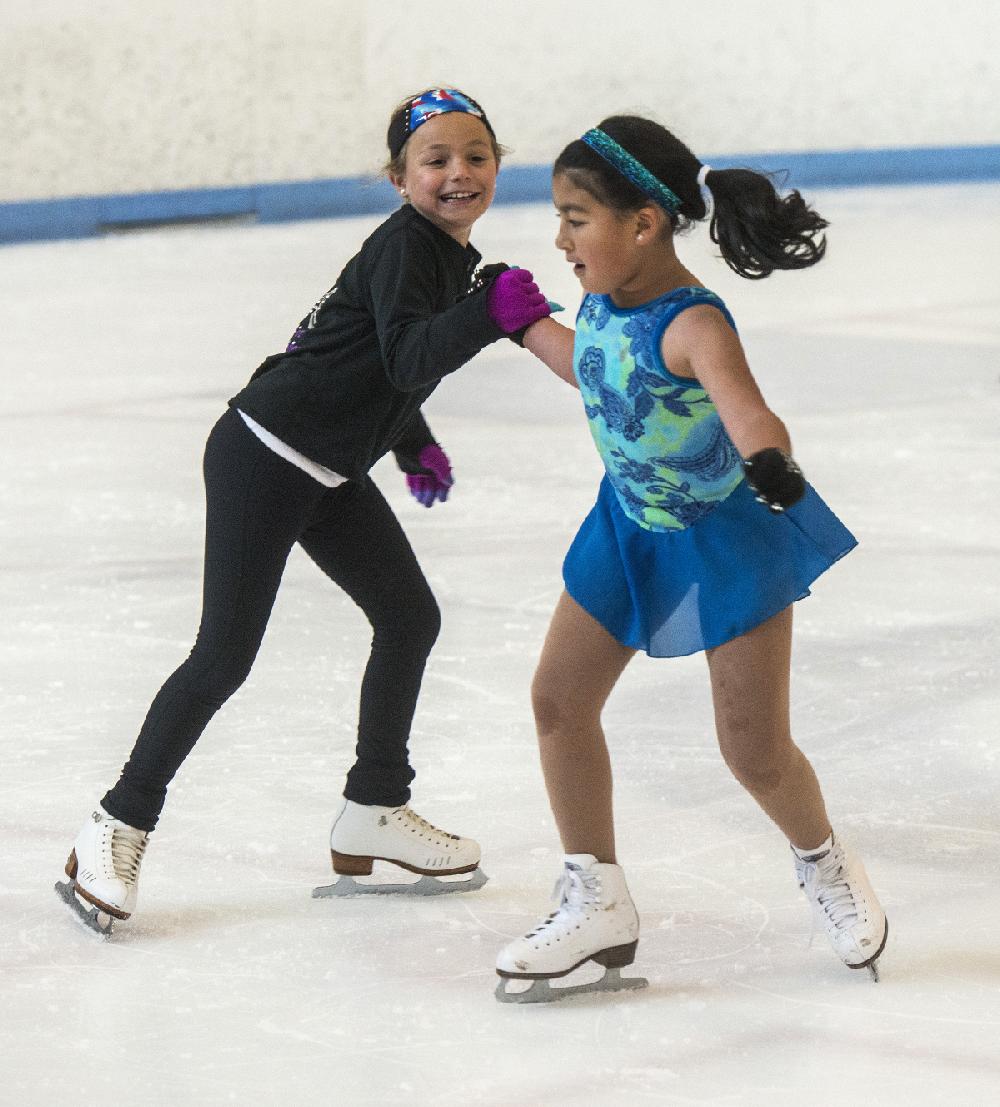 STAFF PHOTO ANTHONY REYES
Ana Sofia De Icaza, right, 8, and Ella Aprea, 8, spins together during a lesson Thursday, June 19, 2014 at a skating camp with the Arkansas Figure Skating Association at the Jones Center in Springdale. The girls joined other beginning and intermediate skaters for the annual figure skating camp. The camp ends today (FRIDAY) but the association will host a basic skills camp next week. Registration is through the Jones Center main number.