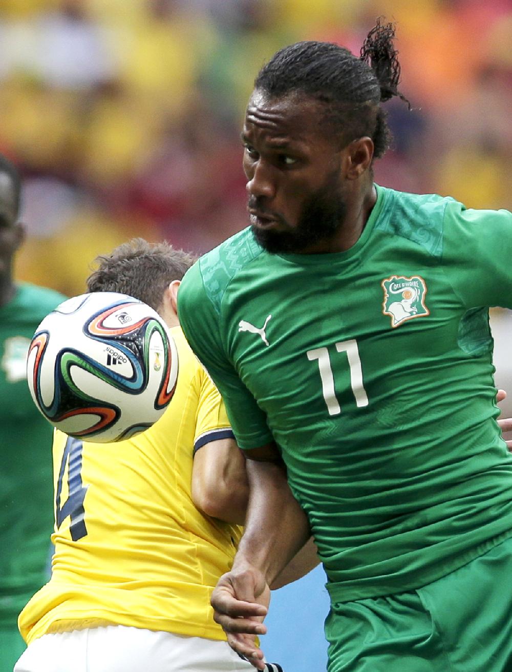 Ivory Coast's Didier Drogba, right, barges his way past Colombia's Santiago Arias, left, during the group C World Cup soccer match between Colombia and Ivory Coast at the Estadio Nacional in Brasilia, Brazil, Thursday, June 19, 2014. (AP Photo/Marcio Jose Sanchez)