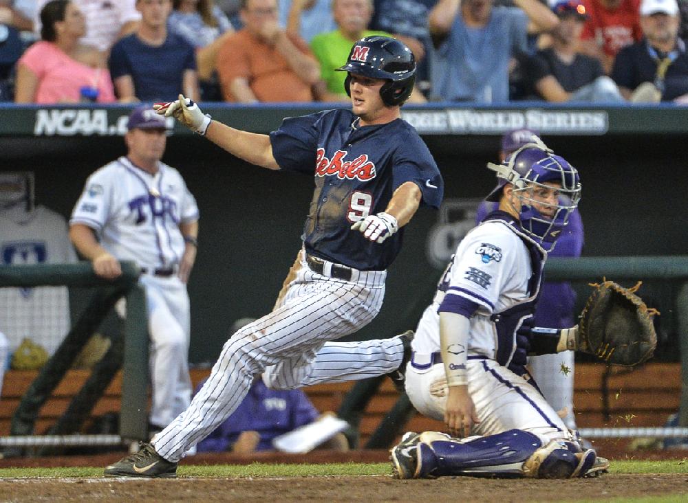 Mississippi's Auston Bousfield (9) runs past TCU catcher Kyle Bacak (6) on his way to score on a single by Sikes Orvis in the fifth inning of an NCAA baseball College World Series elimination game in Omaha, Neb., Thursday, June 19, 2014. (AP Photo/Ted Kirk)